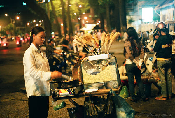 Một người đàn ông đang ăn thịt xiên nướng ở Bắc Kinh, Trung Quốc.